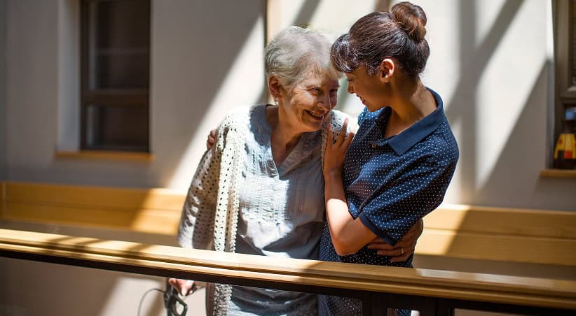 Sourire de deux femmes âgées partageant un moment de complicité.
