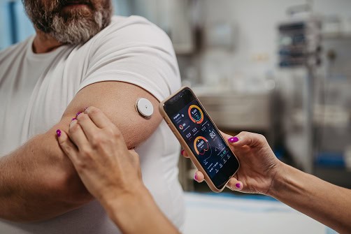 Test de glycémie sur le bras avec un glucomètre connecté.
